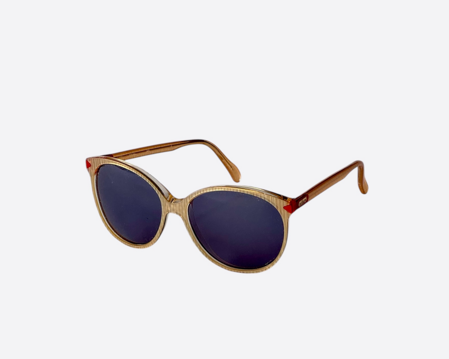 Side view of pre-loved 1980s Cacharel sunglasses with beige frames and new grey lenses, showing the visible Cacharel logo on the temples.