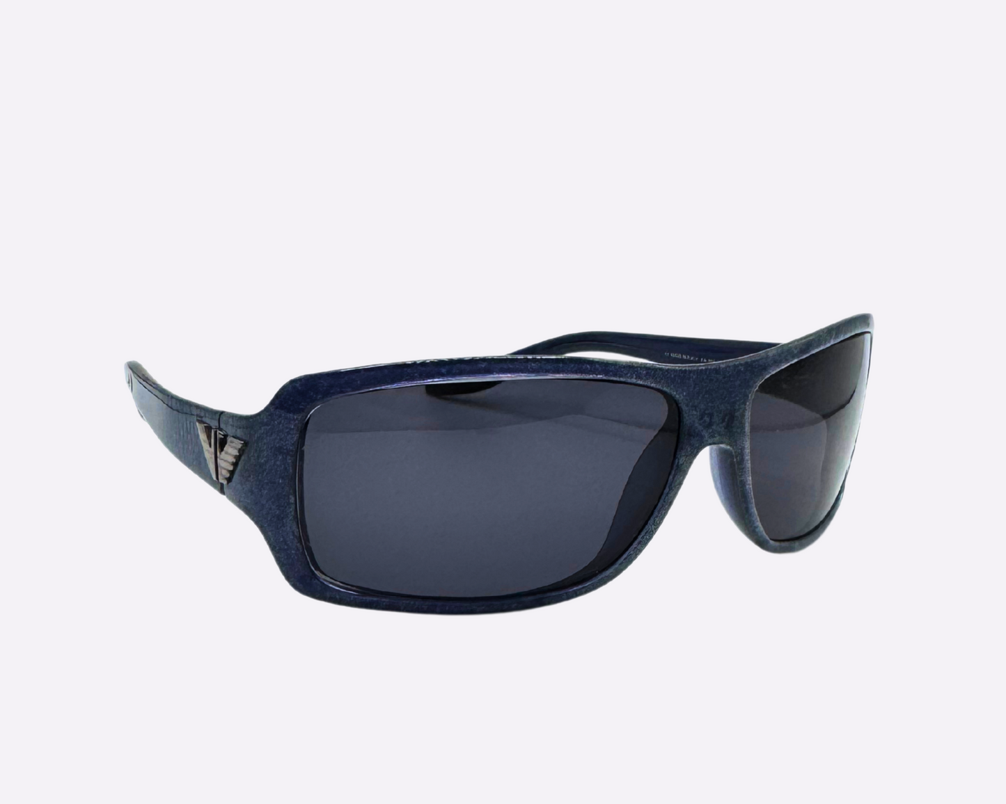 Side view of early 2000s Armani sunglasses made in Italy, with a dark blue speckled frame and new grey lenses, shown on a light gray background.