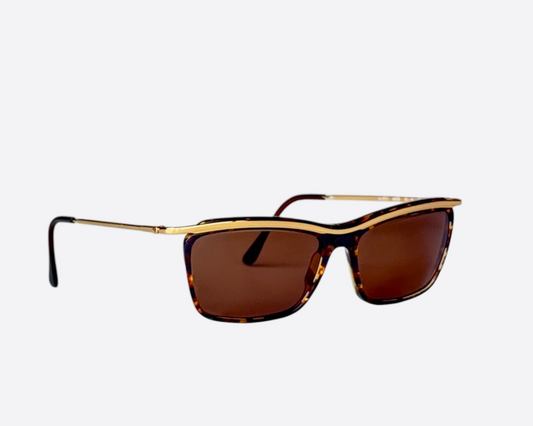 A pair of Vogue eyewear sunglasses, model VO2011 W669, from the 90s with a gold and brown frame and brown lenses.