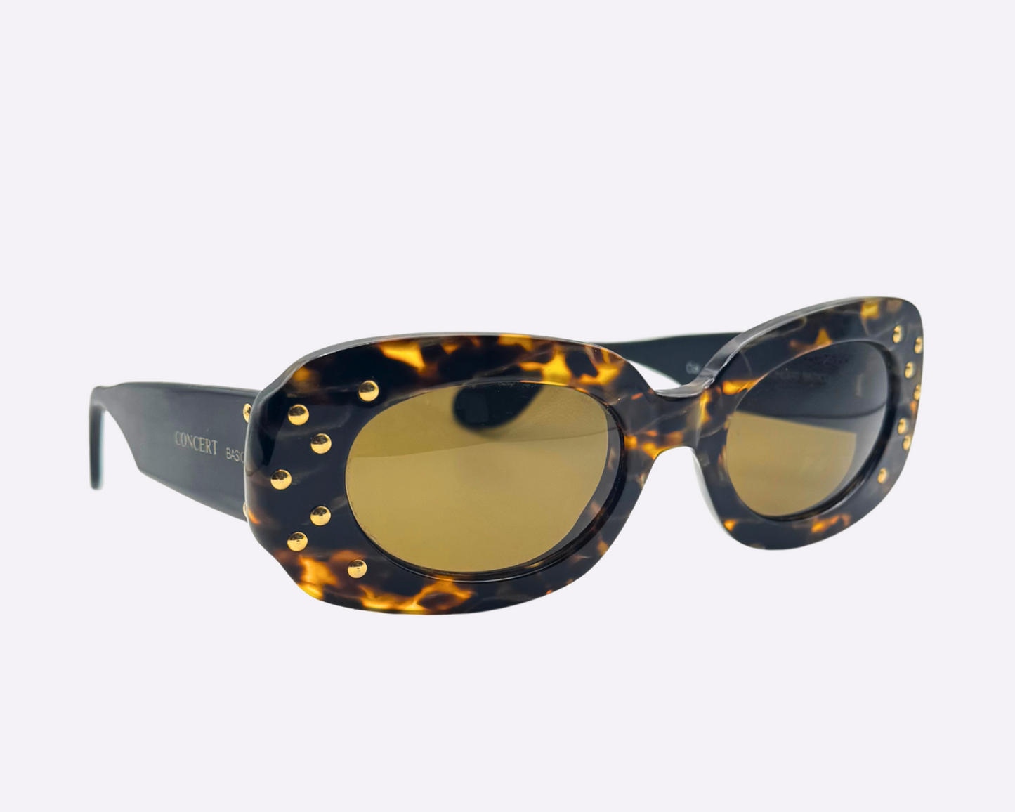 Side view of vintage Concert sunglasses with brown tortoise frames and sparkling gold strass embellishments on the front of the frame, shown on a light gray background.
