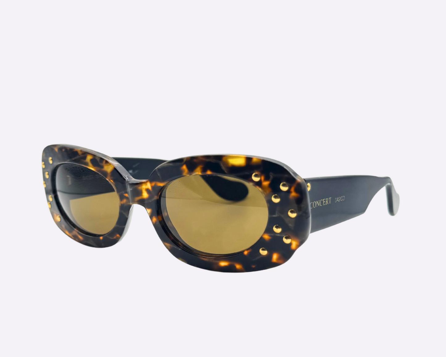 Side view of vintage Concert sunglasses with brown tortoise frames and sparkling gold strass embellishments on the front of the frame, shown on a light gray background.