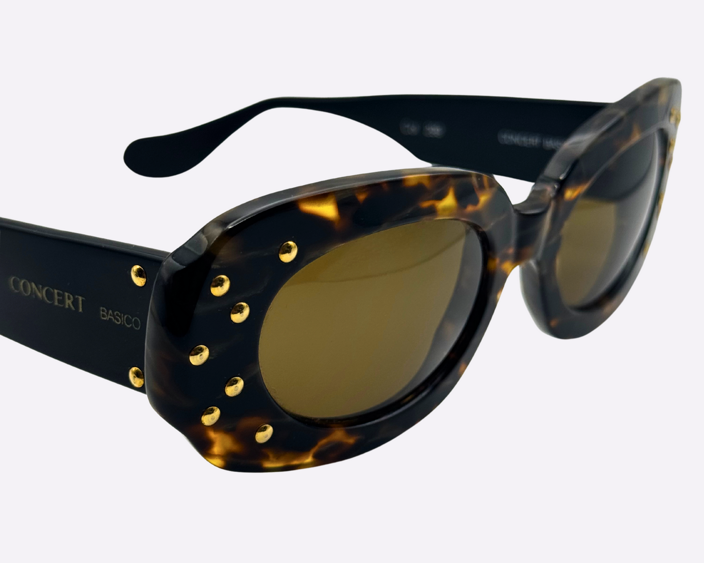 Close-up of vintage Concert sunglasses with brown tortoise frames, highlighting the dazzling gold strass embellishments on the front of the frame.
