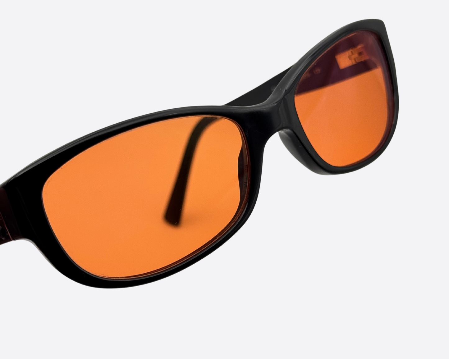 Extreme close-up on the front of the black DG3125 frame, highlighting the clarity and intense color of the new orange lenses.