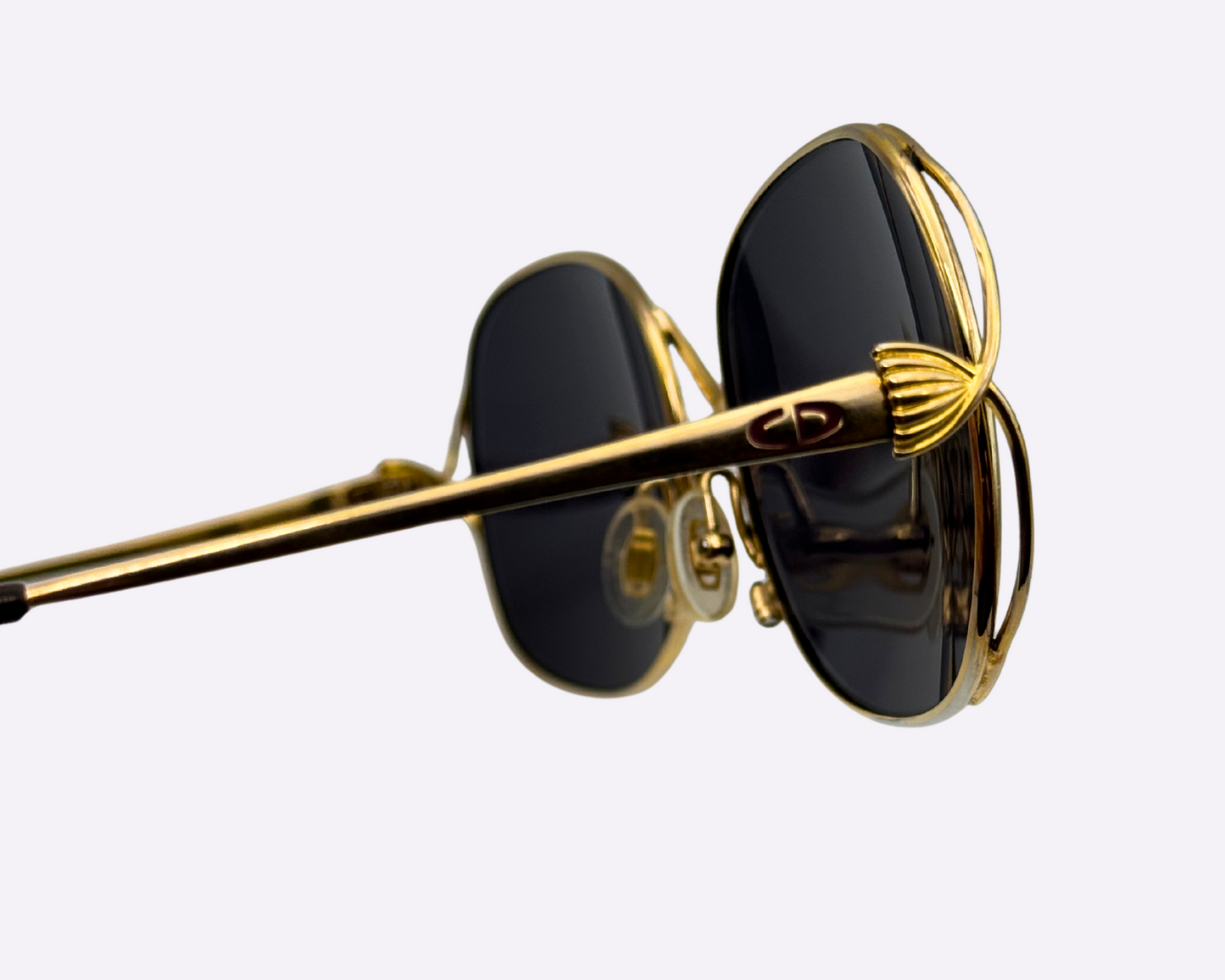 Close-up of the temple and Dior logo on vintage 1980s Christian Dior sunglasses with a steel frame and new grey lenses.