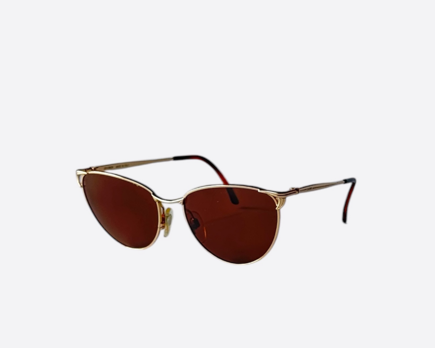 Side view of a pair of Les Copains sunglasses, model LC109, made in Italy, featuring a cat-eye frame design and new brown lenses.