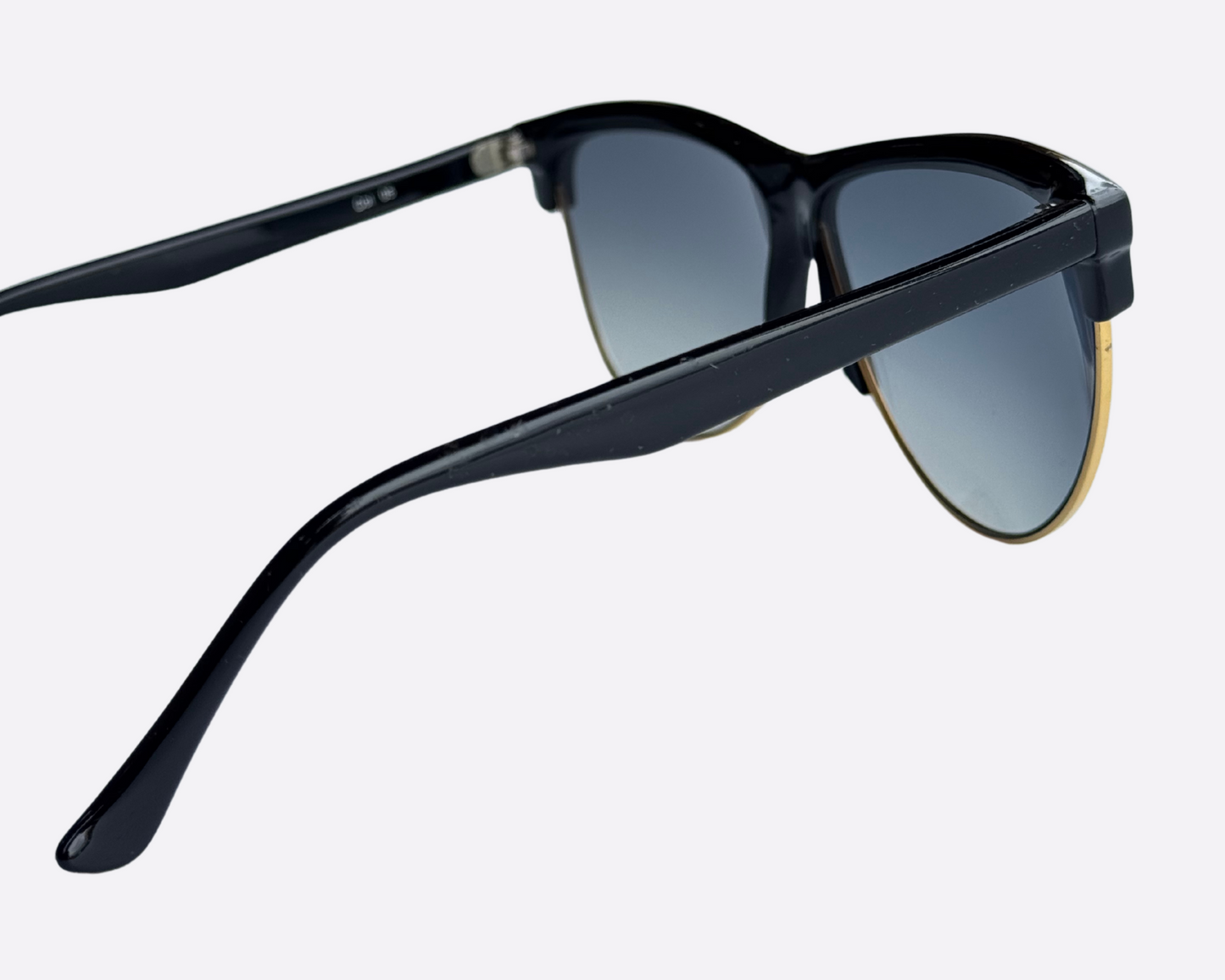 Side view of Italian-made Piave 272 sunglasses with black frames and new grey gradient lenses, displaying the sculpted temples against a neutral backdrop.