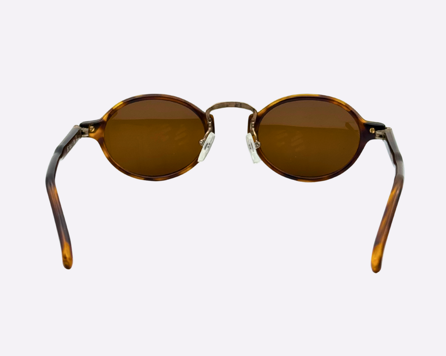 Rear view of vintage 1990s round sunglasses with a tortoiseshell frame and newly replaced brown lenses, photographed on a white background.