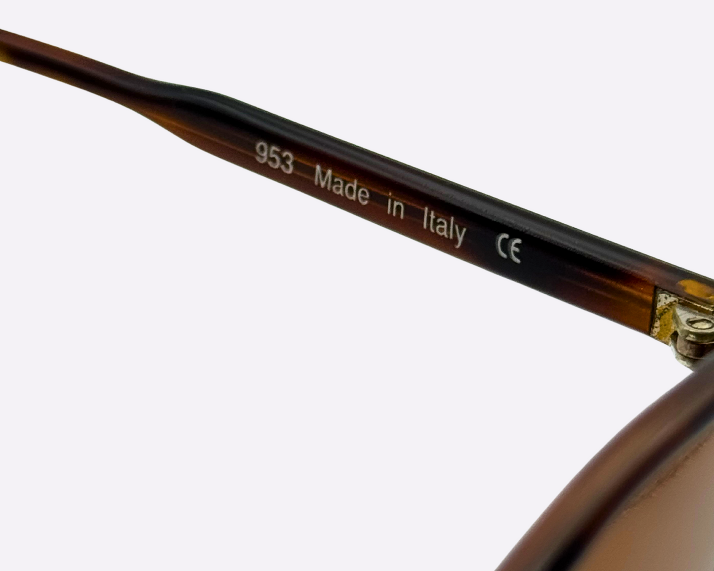 Close-up of a tortoiseshell eyeglass frame with 'Made in Italy' and CE marking on a white background.