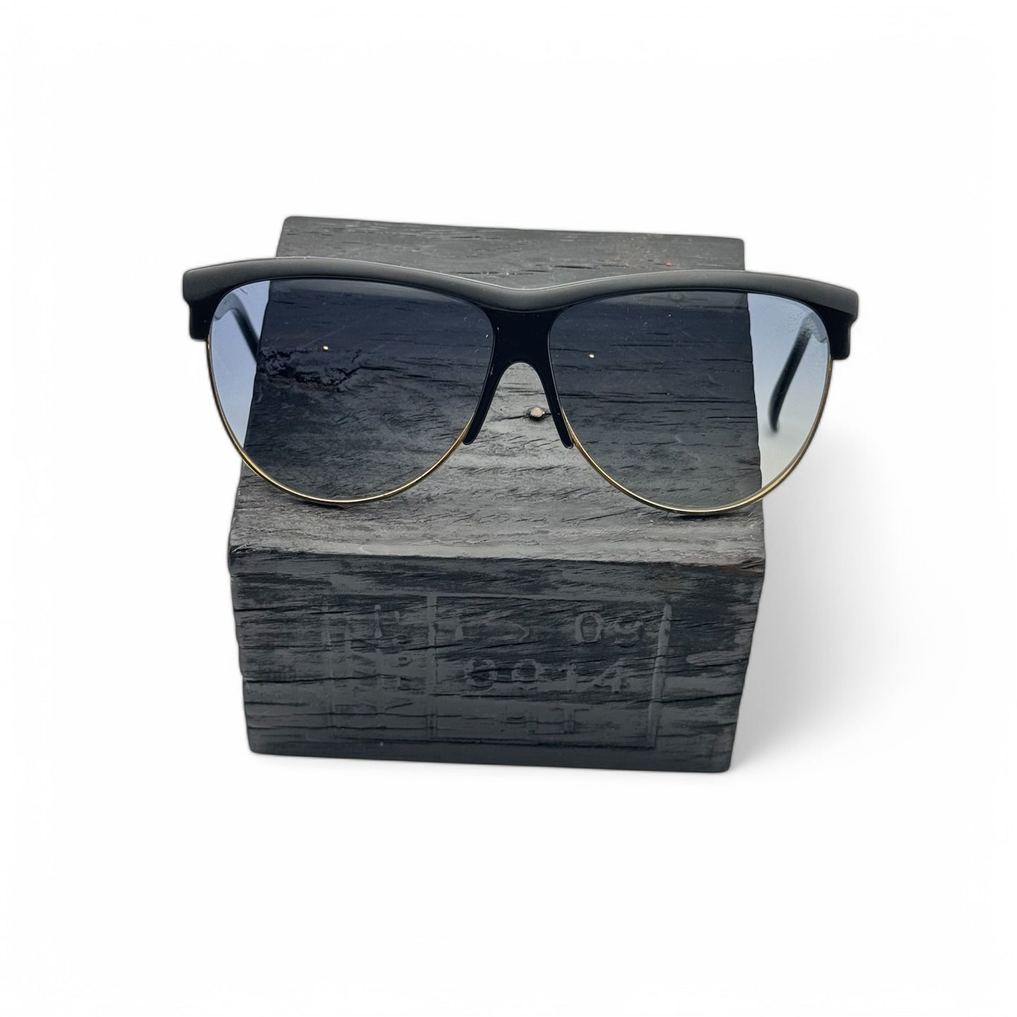 Front view of Piave model 272 sunglasses, made in Italy, featuring black frames with a gold metal lower rim and new grey gradient lenses.