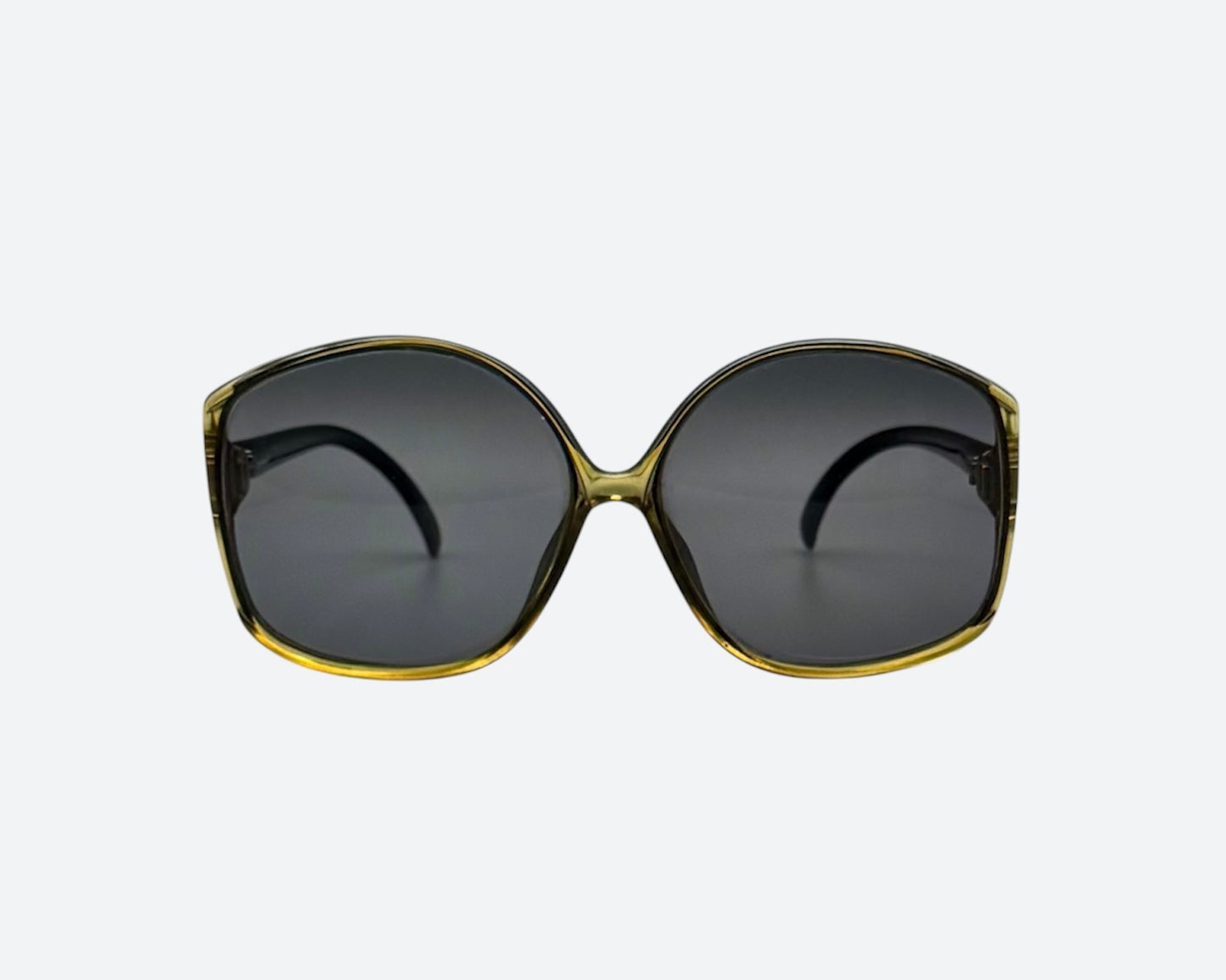 Front view of a pair of vintage Optyl sunglasses with a tinted green frame and dark lenses, crafted in Germany.