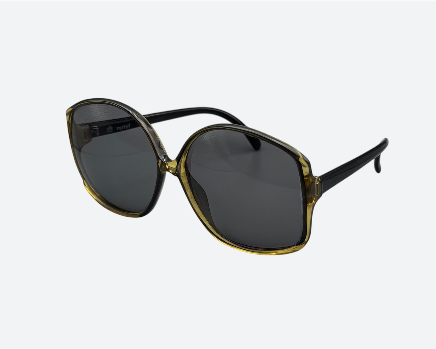 Side view of a pair of vintage Optyl sunglasses with a green tinted frame and dark lenses, crafted in Germany in the 70s or 80s.