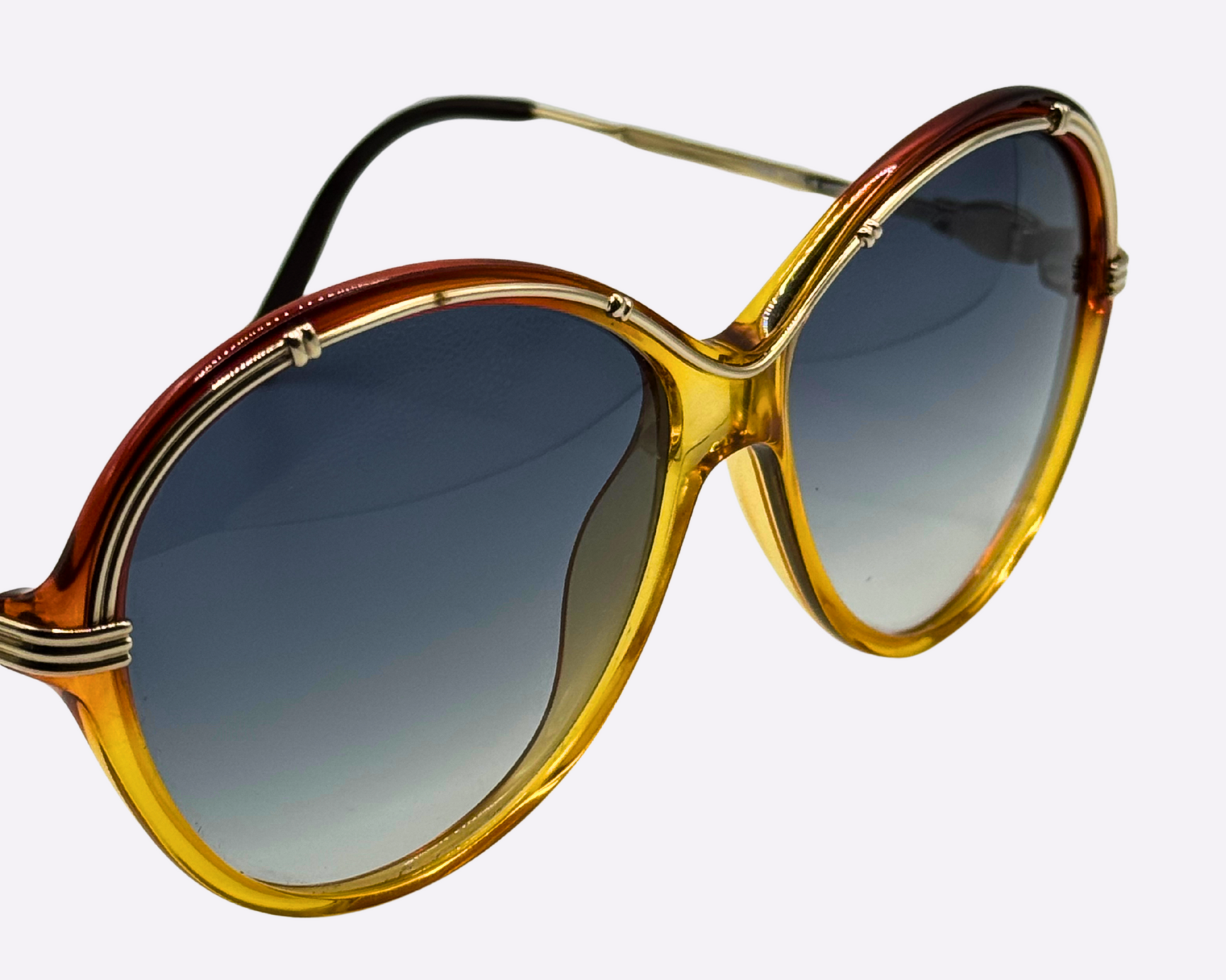 Close-up of the gold metal and red-and-gold optyl frame with new grey gradient sunglass lenses.