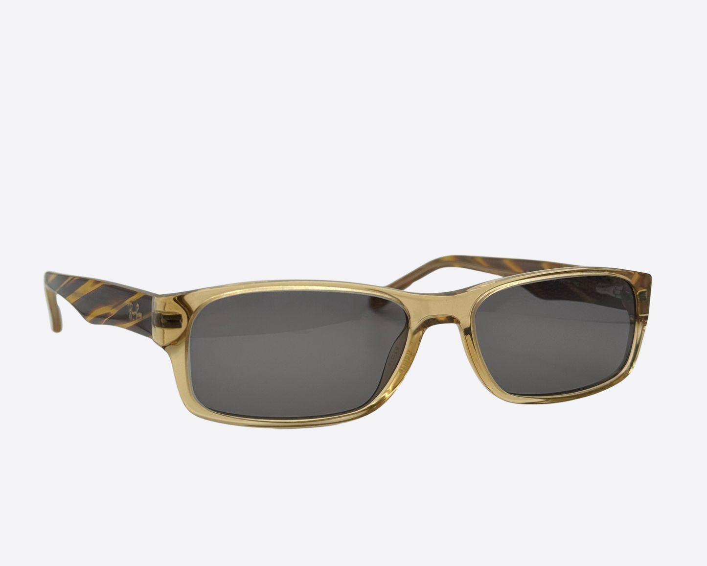 Vintage-style Ray-Ban sunglasses featuring translucent honey-colored frames and patterned temples.