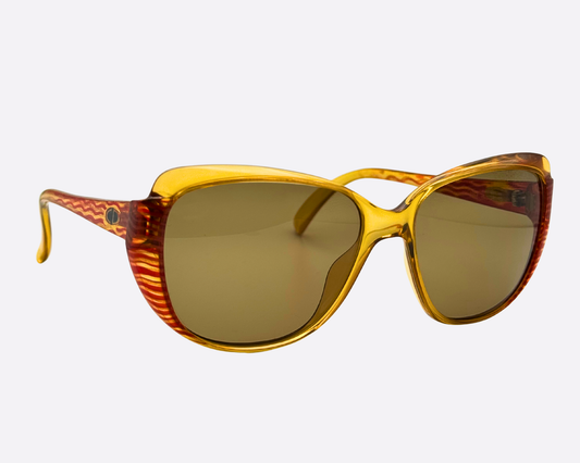 Angled front view of the 80s Christian Dior 2202 sunglasses. Shows the vibrant yellow frame and the distinctive red/orange striped pattern on the sides.