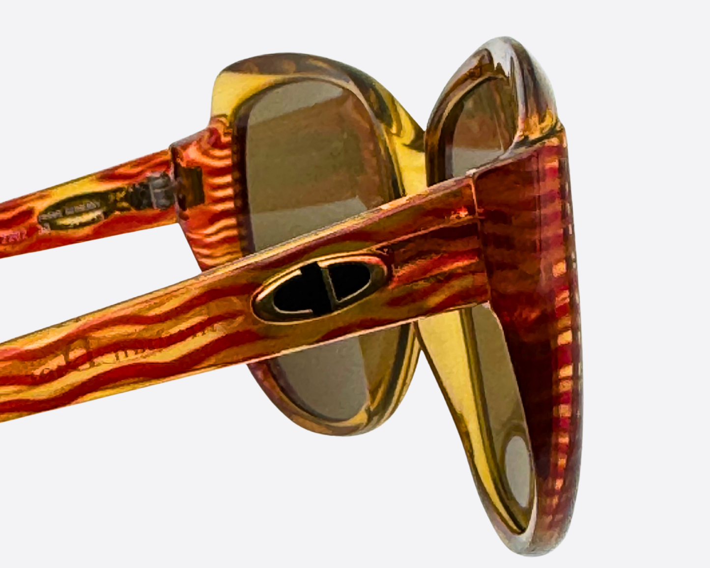 Close-up of the side of the Christian Dior 2202 frame, showing the gold CD logo detail and the distinctive red/orange wavy pattern on the temple.