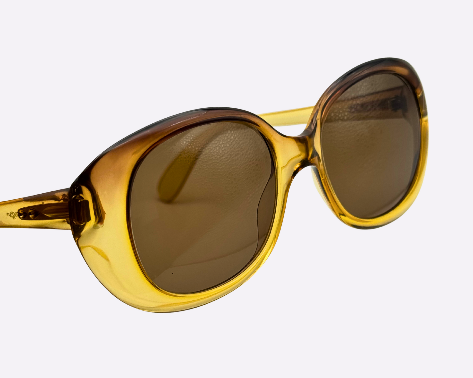 Close-up on vintage 1980s Terri Brogan sunglasses, model 8752 80, with thick gold optyl frames and new brown lenses, shown on a light gray background.