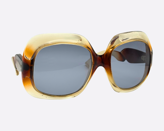 Side view of 70s French couture sunglasses showing the thick sculptural acetate temples with a translucent honey and brown two-tone finish.