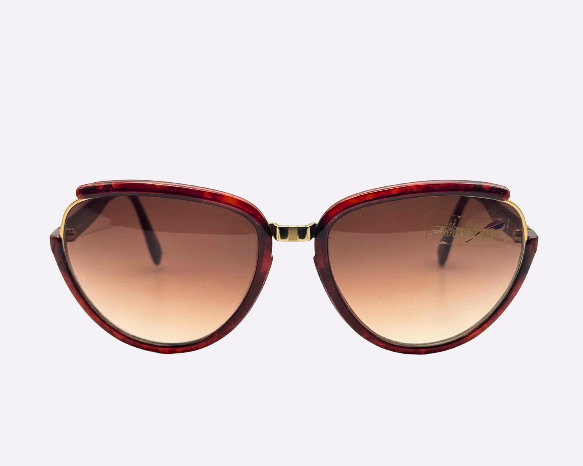 Front view of vintage 1980s Silhouette M8023/20 cat-eye sunglasses with gold and tortoise optyl and metal frame and original brown gradient lenses, shown on a light gray background.