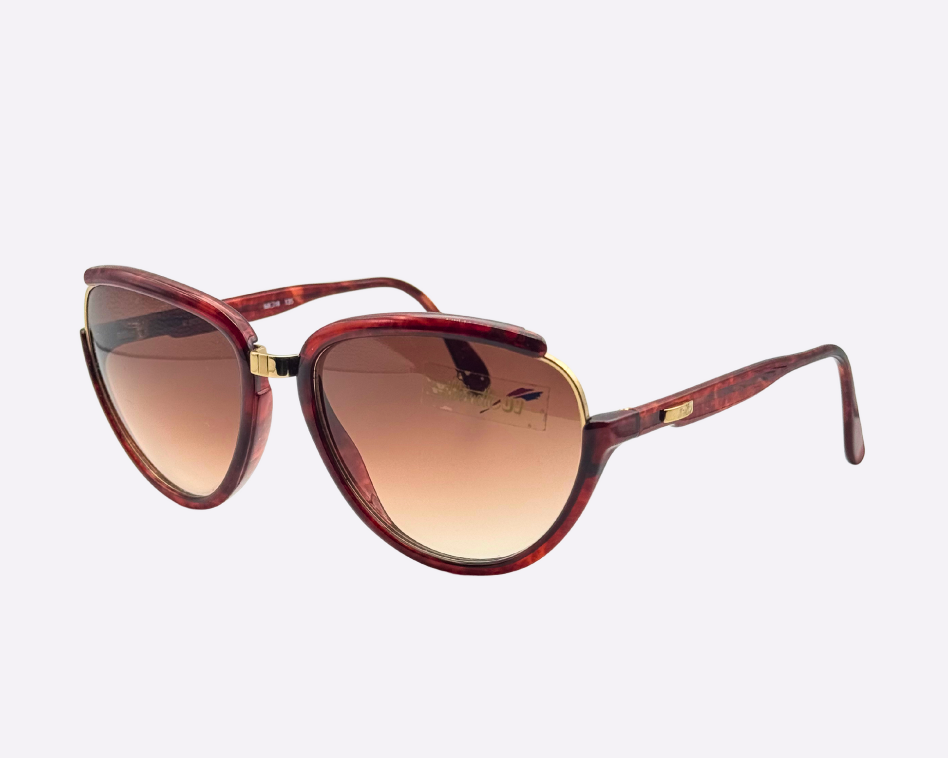 Side view of vintage 1980s Silhouette M8023/20 cat-eye sunglasses featuring a gold and tortoise frame made of optyl and metal, with original brown gradient lenses, shown on a light gray background.
