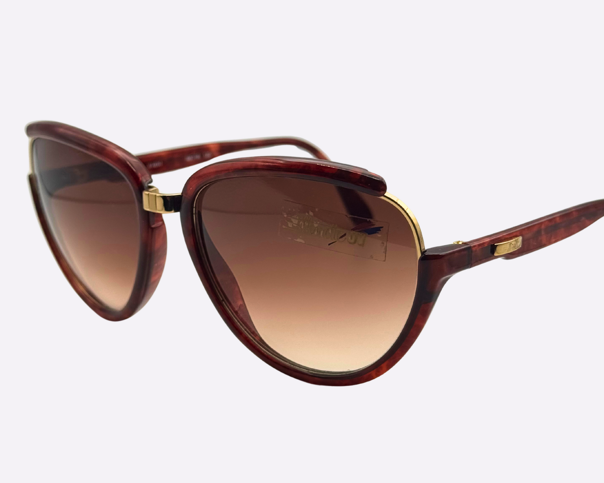 Side view of vintage 1980s Silhouette M8023/20 cat-eye sunglasses featuring a gold and tortoise frame made of optyl and metal, with original brown gradient lenses.
