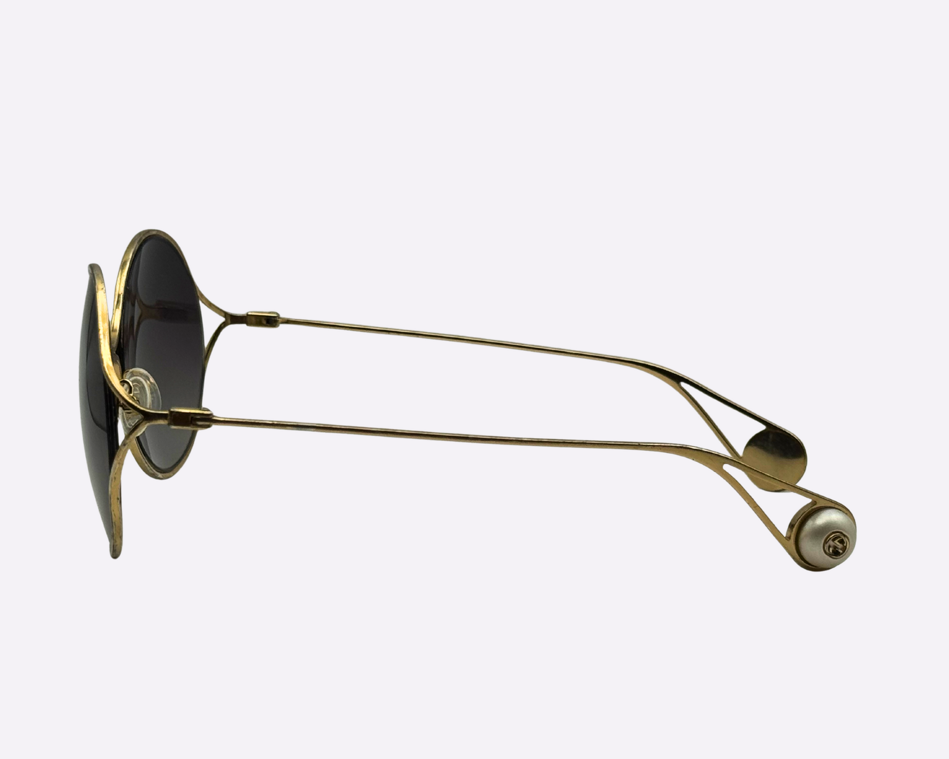 Side view of Gucci oversize sunglasses with a steel frame and new grey lenses, showcasing the sleek steel temple and round pearl logo at the temple tip