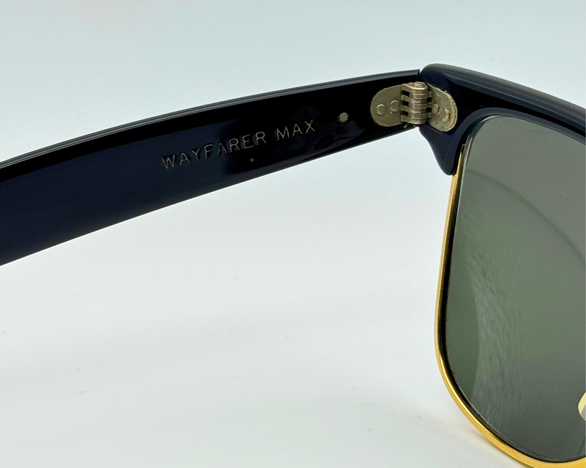 Sunglasses with 'WAYFARER MAX' on the frame against a light background