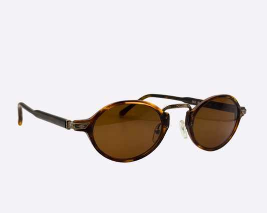 Side view of vintage 1990s round sunglasses with brown lenses and a tortoiseshell frame, shown on a white background.