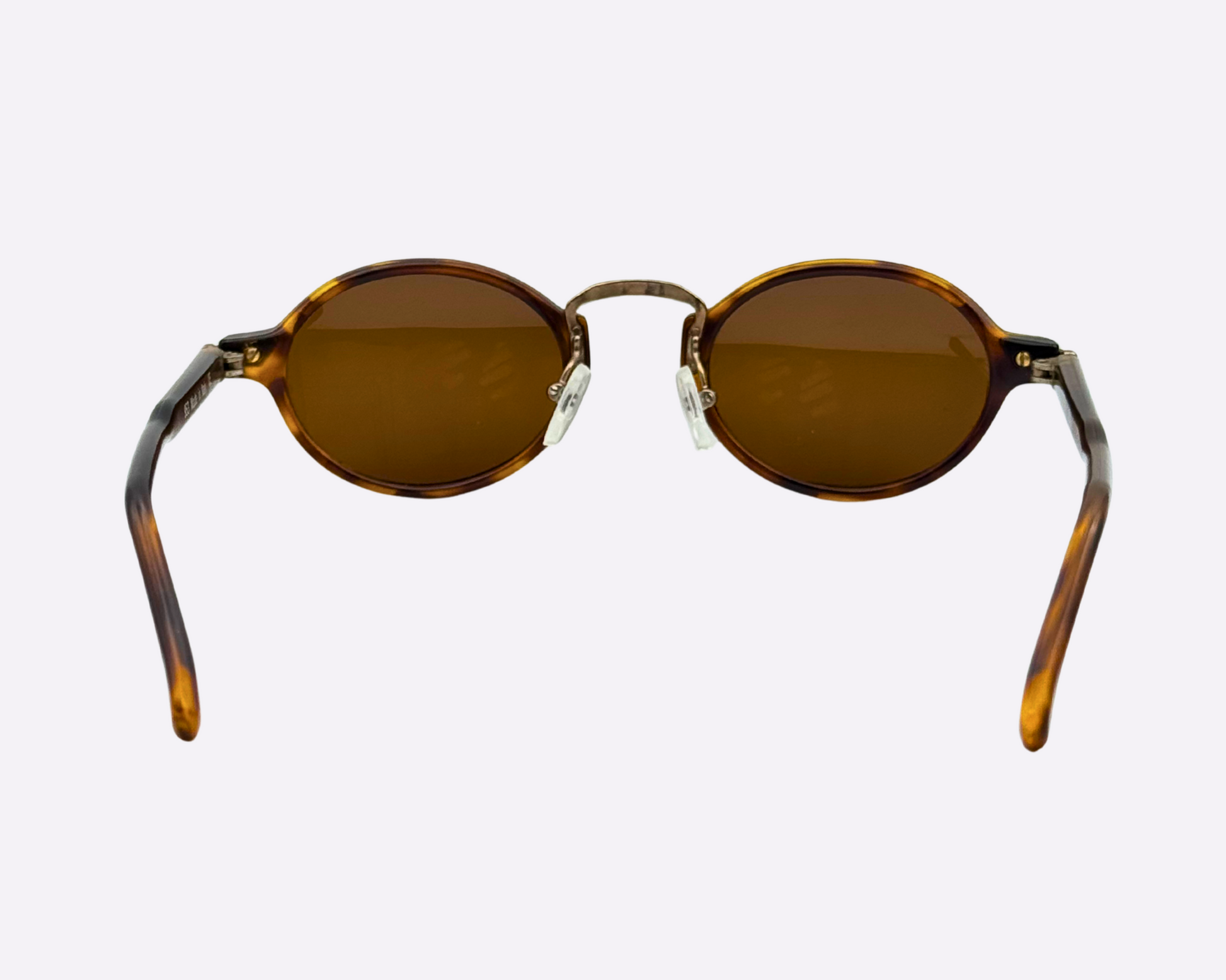 Rear view of vintage 1990s round sunglasses with a tortoiseshell frame and newly replaced brown lenses, photographed on a white background.