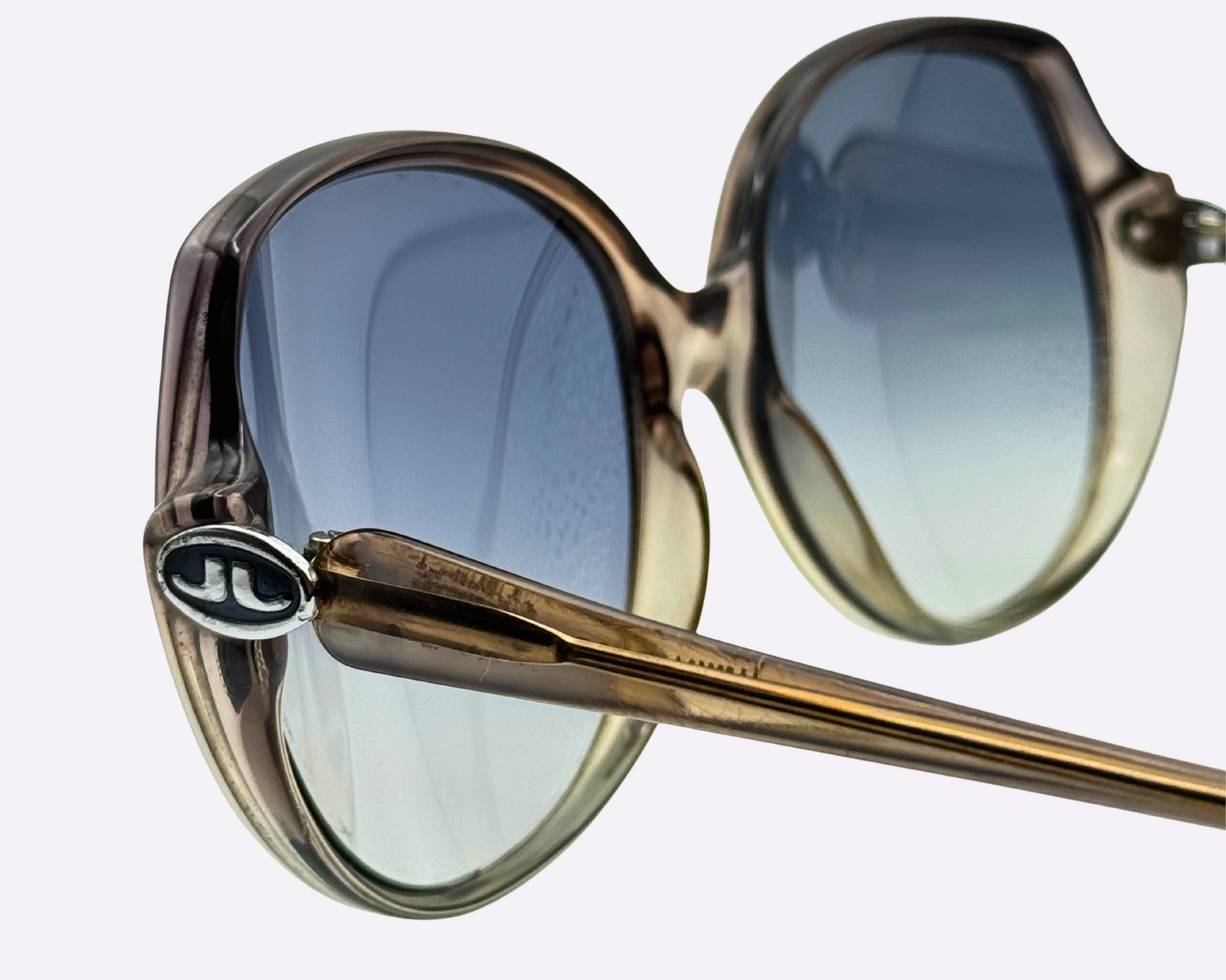 Close-up of vintage Indo sunglasses from the 1980s, showing JL logo and new grey-blue gradient lenses.