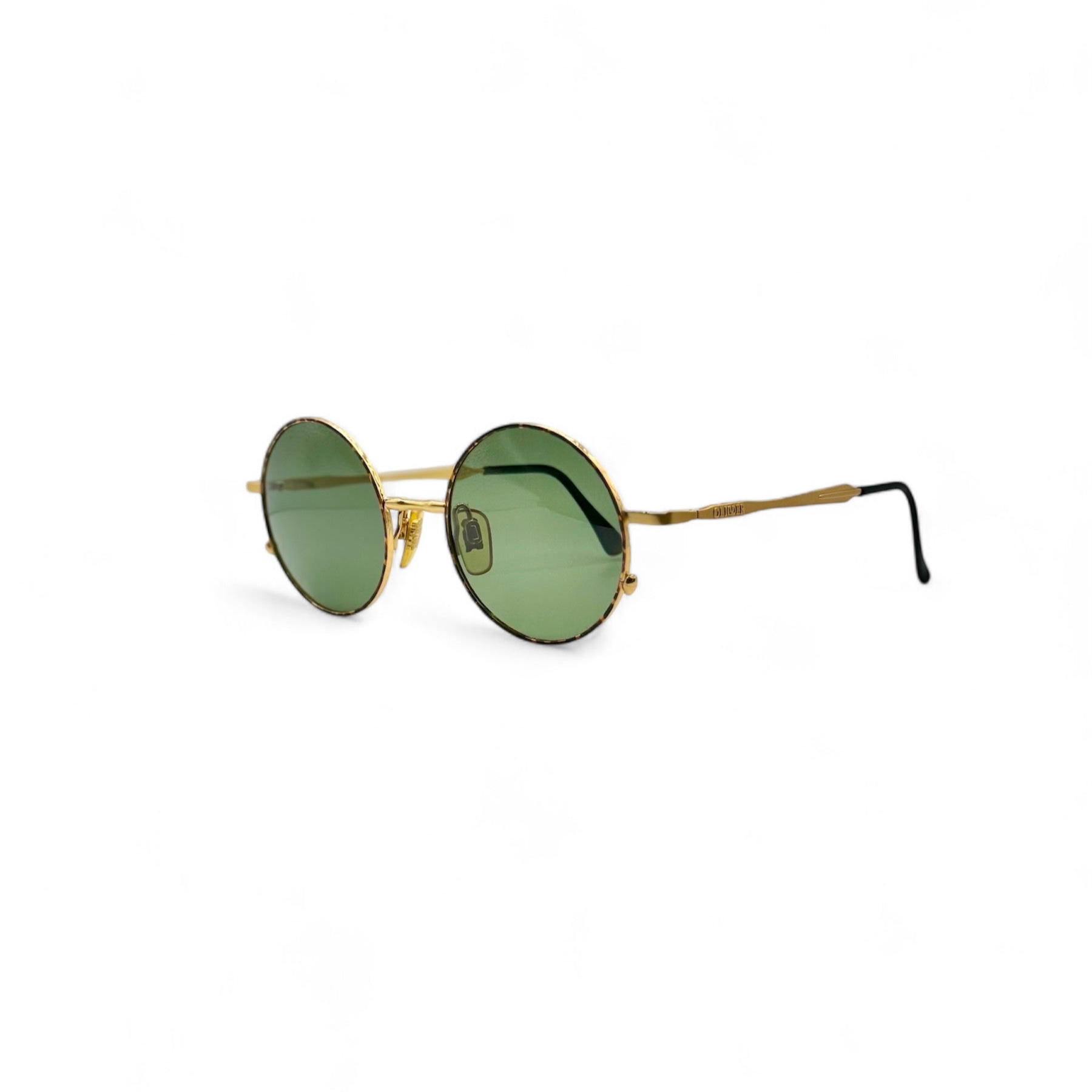 Side-angled view of vintage 90s sunglasses featuring green lenses, gold frames, and a thin brown speckled pattern around the rims. These OLIVER by Valentino frames, crafted in Italy, showcase a sleek, retro-inspired design