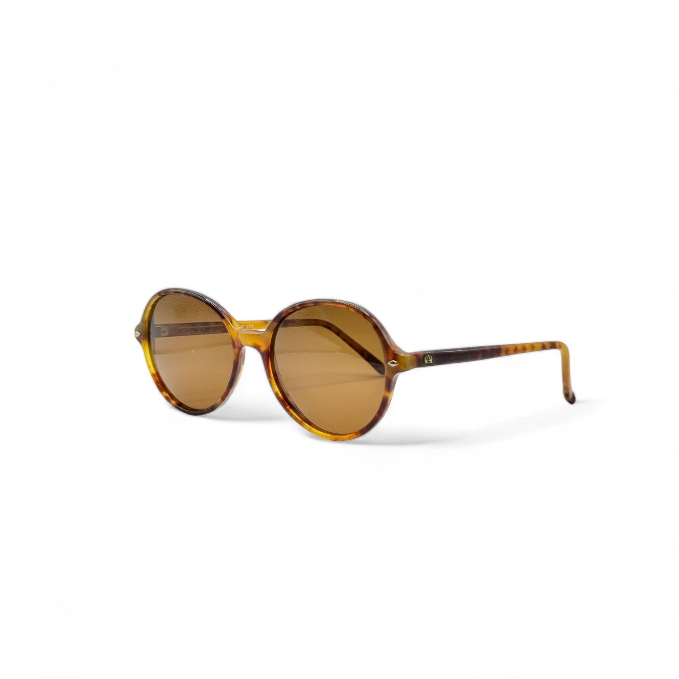 Brown round sunglasses viewed from the side, highlighting their sleek temples and timeless frame design – perfect for sunny days with a retro flair.