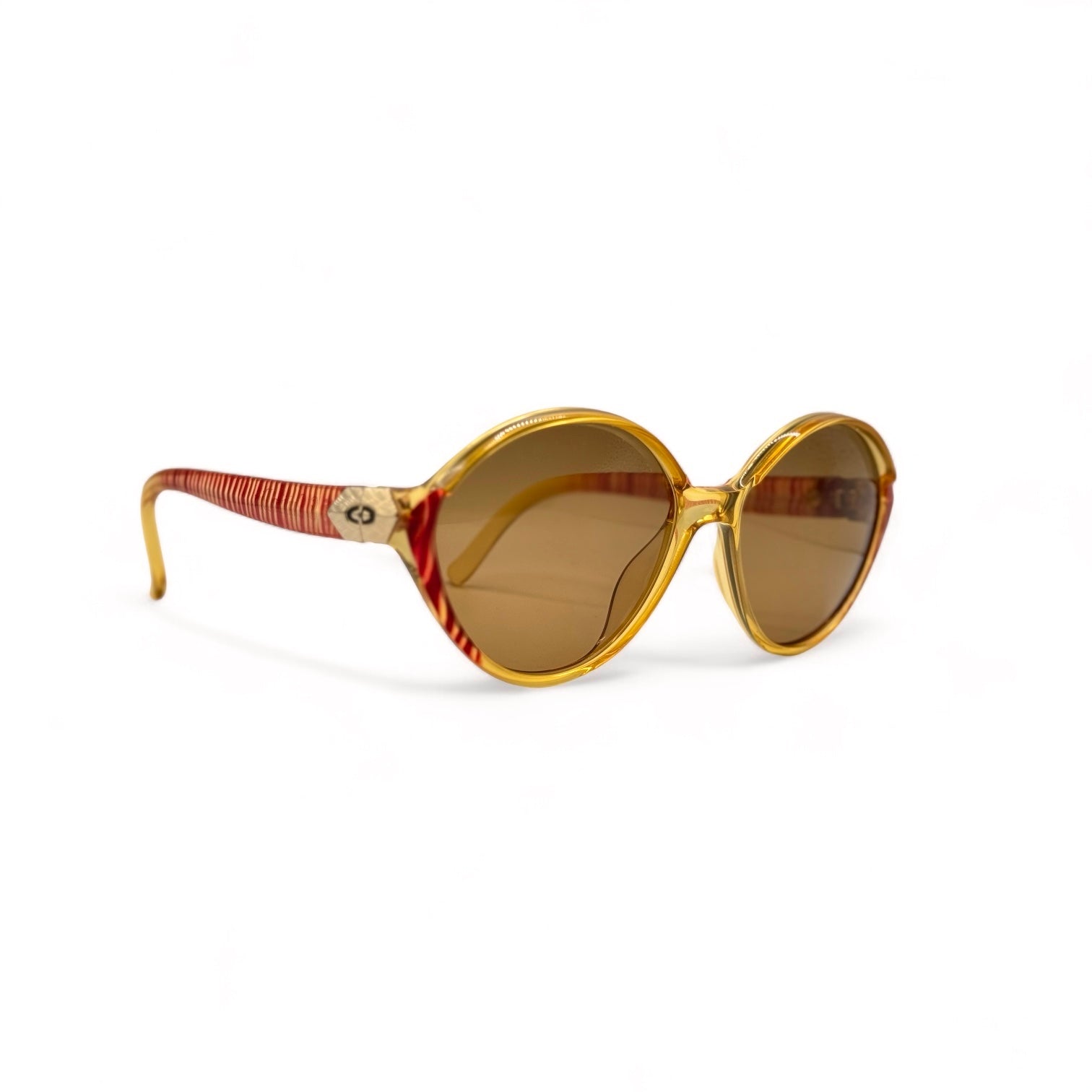 Side profile of Christian Dior sunglasses with gold and red zebra striped frames made in Germany. The temples feature gold metal plates with the iconic CD logo, providing a luxurious, lightweight design.